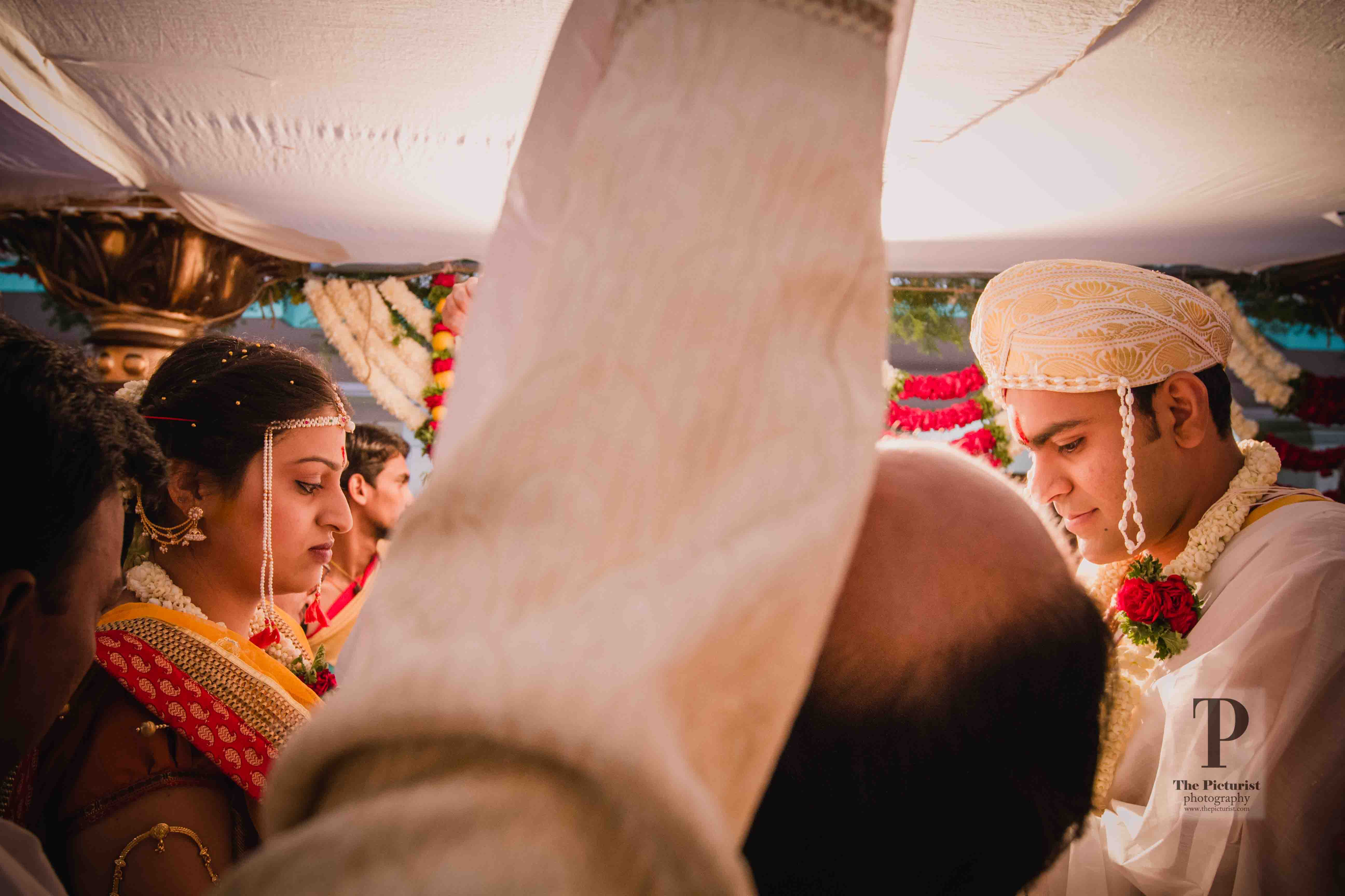mithun and vaishnavi on opposite sides of the cloth before the wedding starts