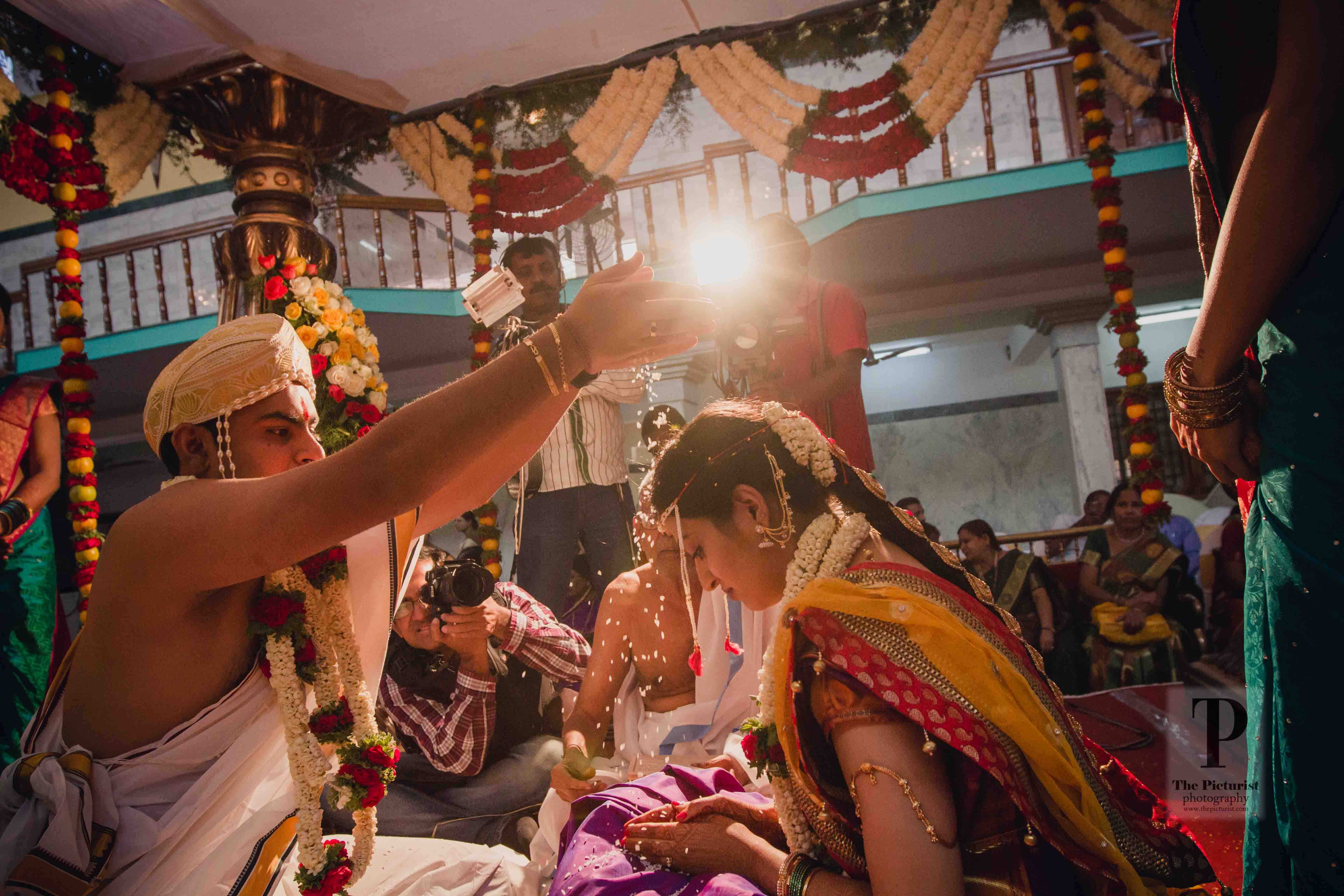 groom showers the bride with sacred rice during the wedding