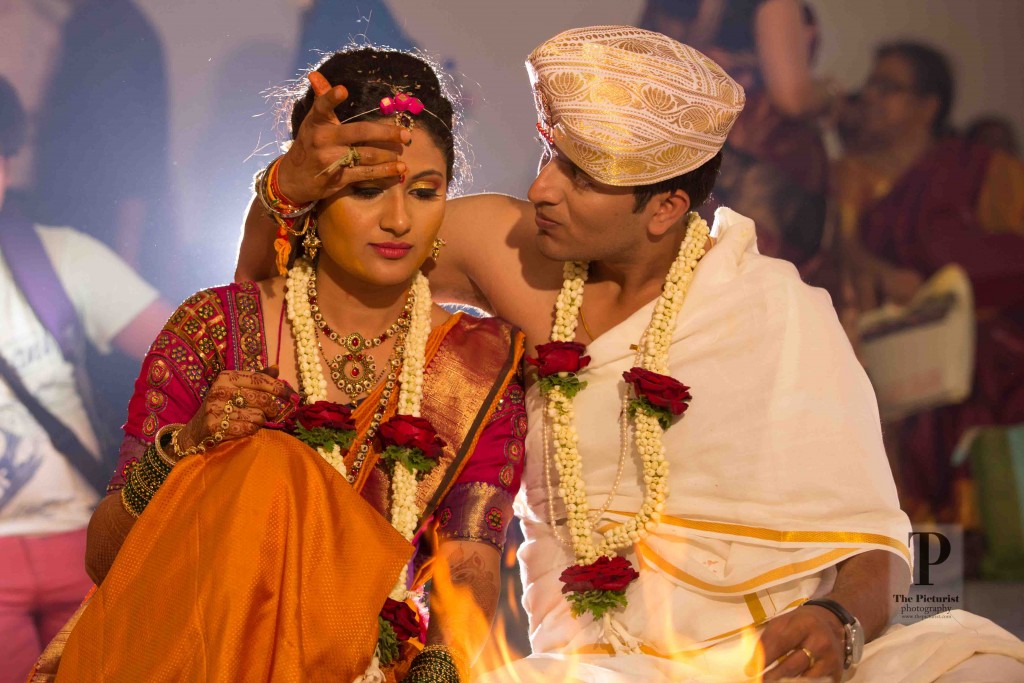 South Indian Groom applying kumkum to the bride in bangalore
